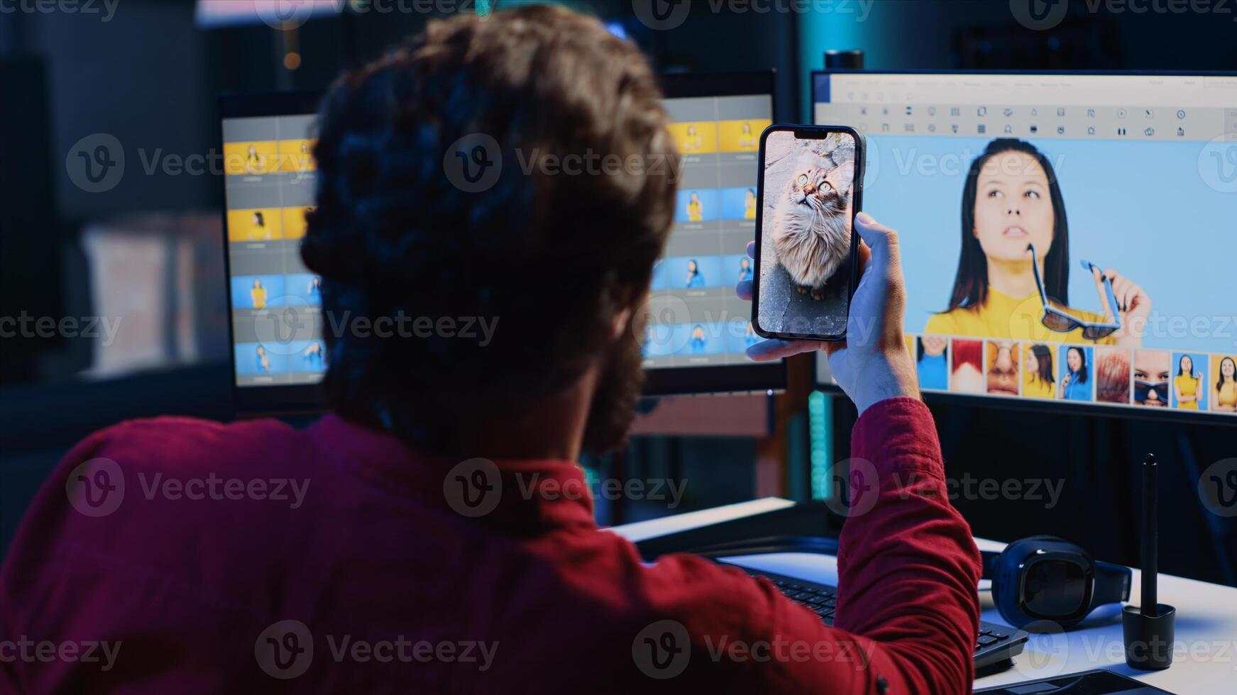 Photo editor tired after retouching images with editing software all day, taking break by looking at funny videos on smartphone. Photographer relaxing after adjusting images, looking at cats on phone