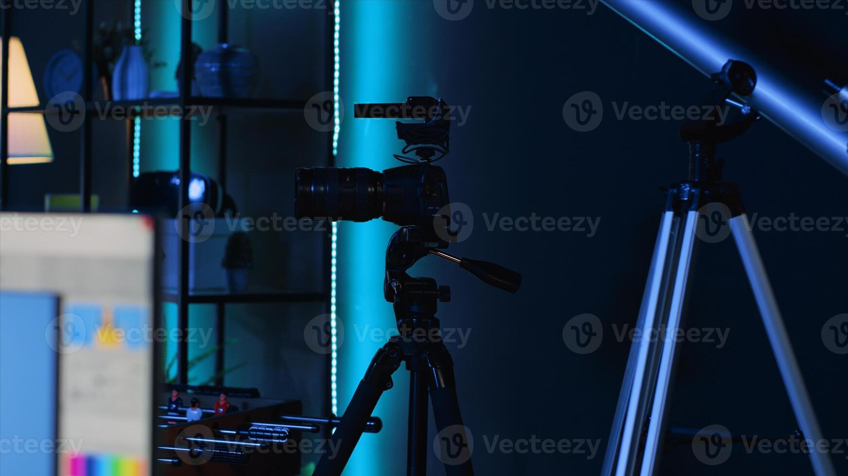 Professional camera equipment in empty blue neon lit creative photography studio. production gear in multimedia agency office specialized in post production editing photo