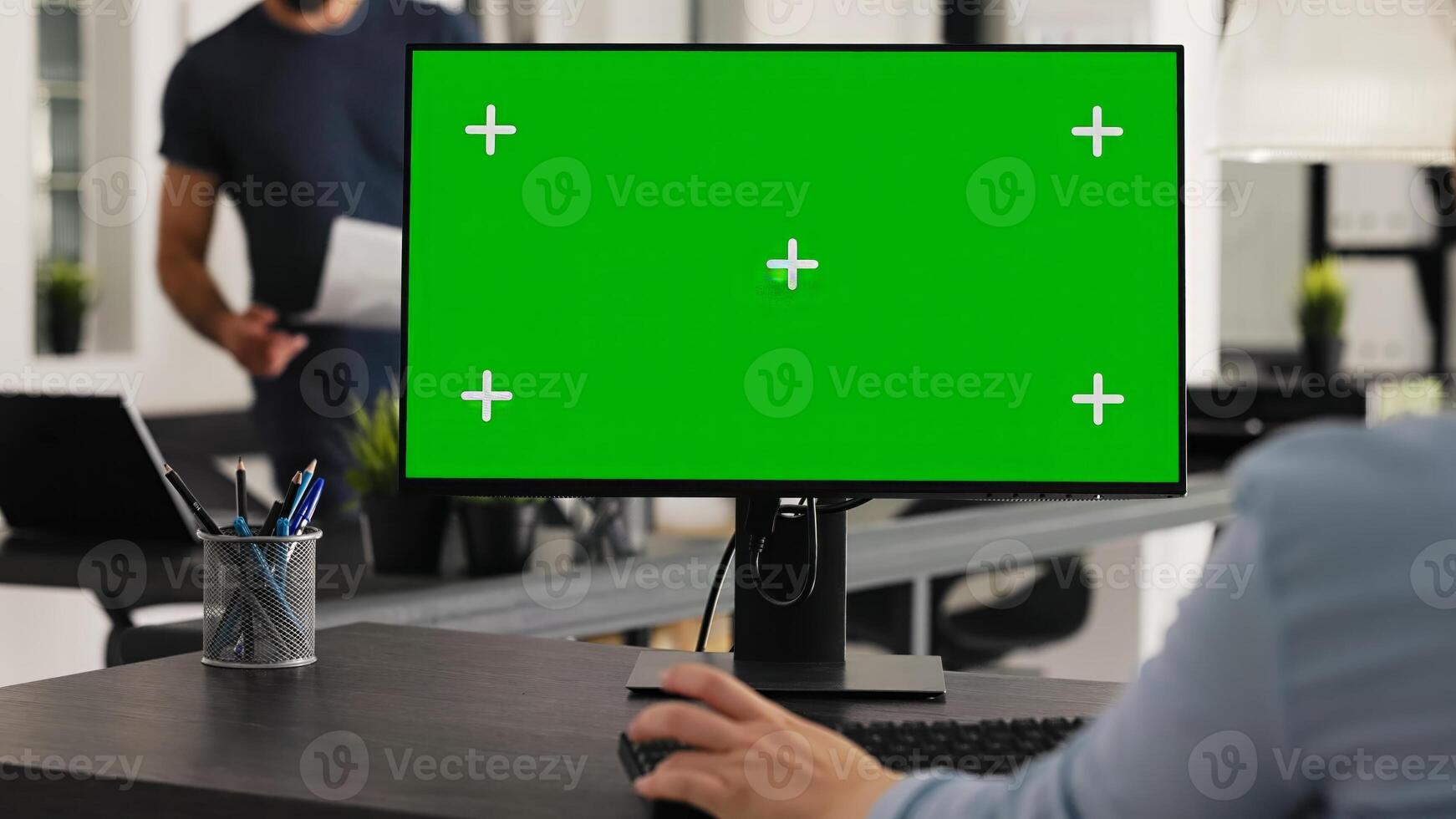 Worker at desk with greenscreen desktop, analyzing isolated computer layout with chromakey copyspace template. Woman sitting at workstation using blank display on pc to work on startup. photo