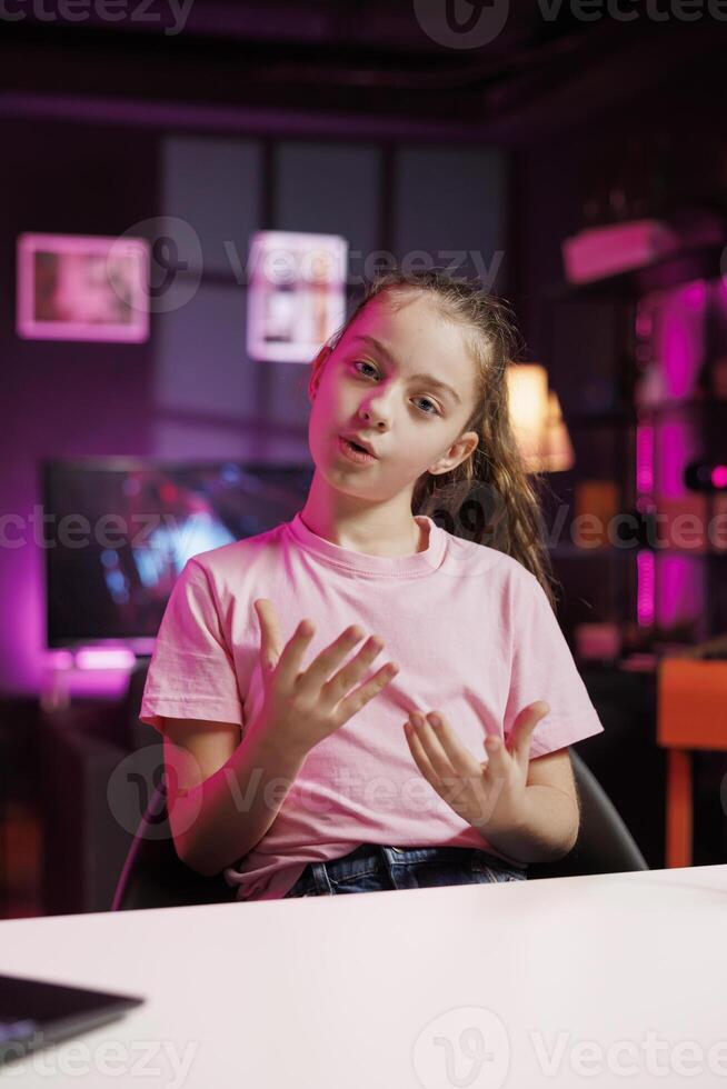 Gen Z entertainer utilizes high quality recording gear to shoot introductory segment for vlog. Young internet star in pink neon studio welcomes devoted fan community, introducing today subject photo