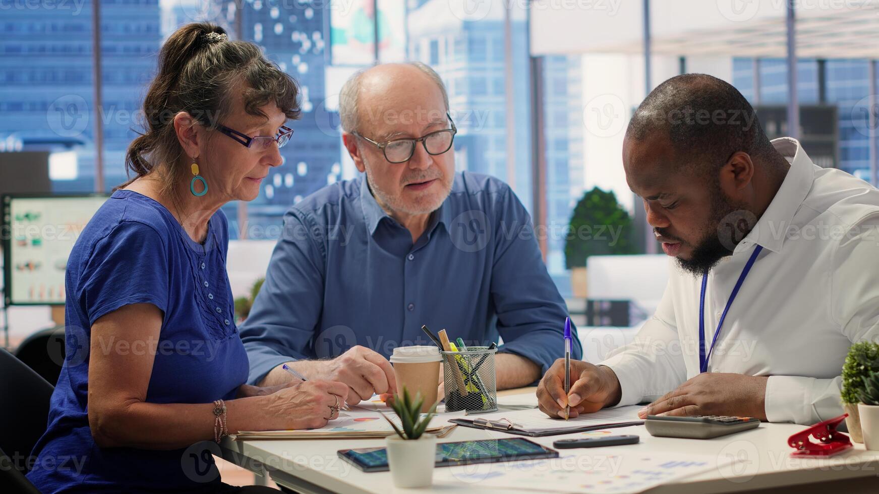 Financial planner helping senior couple with various retirement strategy to increase pension funds and protect life savings. Exploring various options to secure family expenses. Camera A. photo