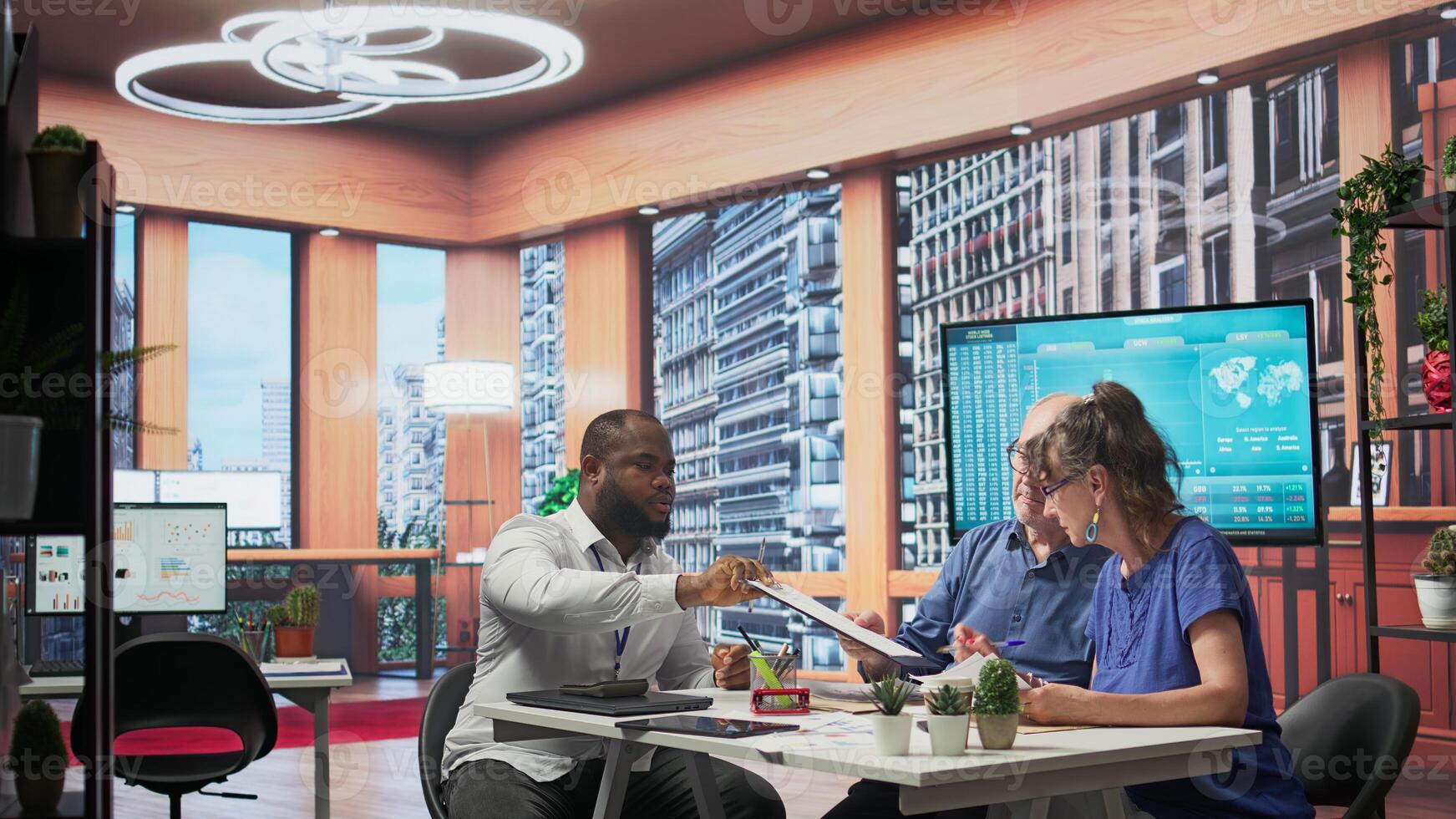 Senior clients receiving guidance and counseling advice on pension planning, discussing potential investment strategy to secure their future income for the long term. Agency planner. Camera B. photo