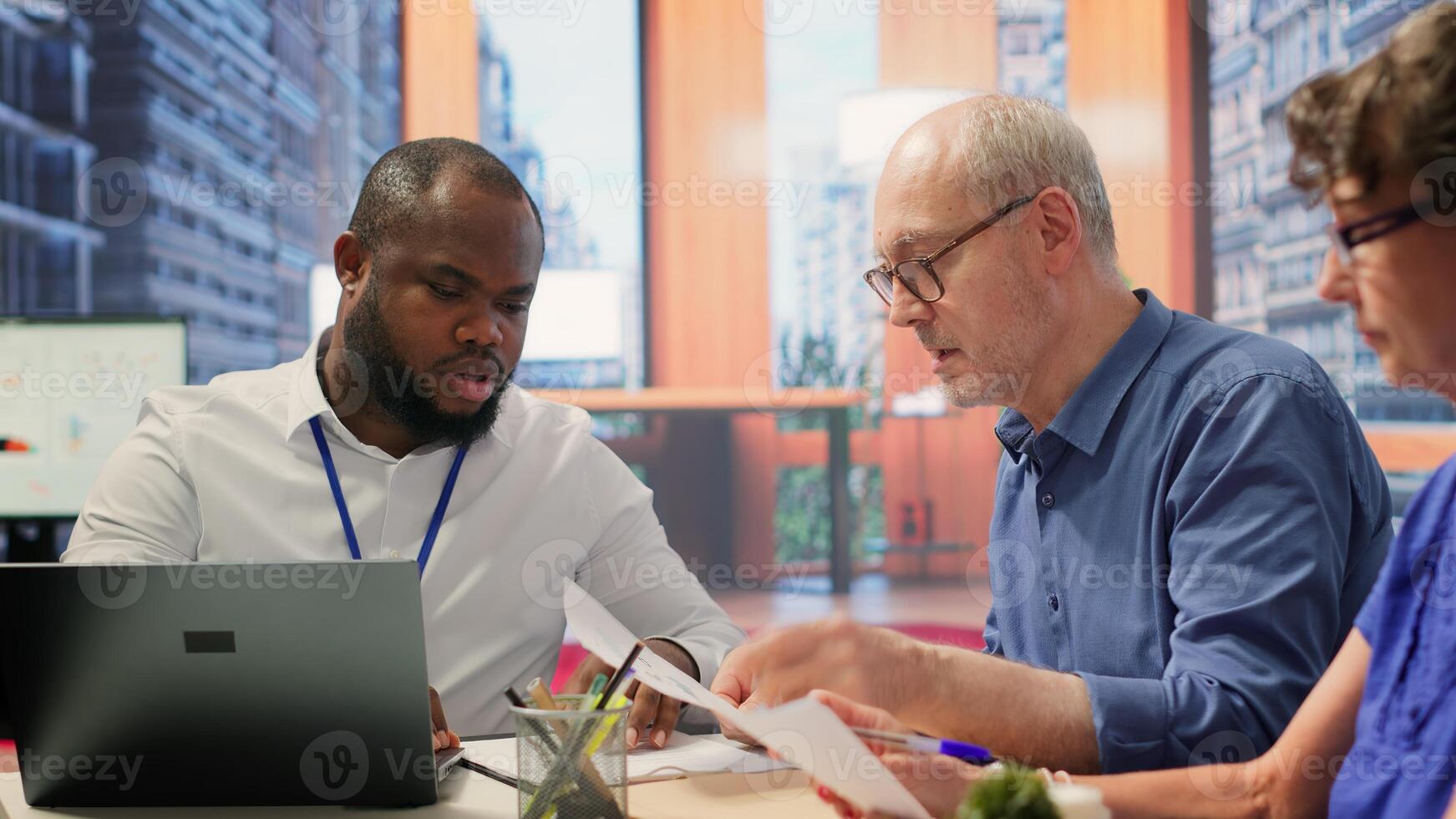 Elderly pair meeting with financial expert to examine various pension options, protect income and investments. Mature couple discuss with advisor about retirement plans and savings. Camera A. photo