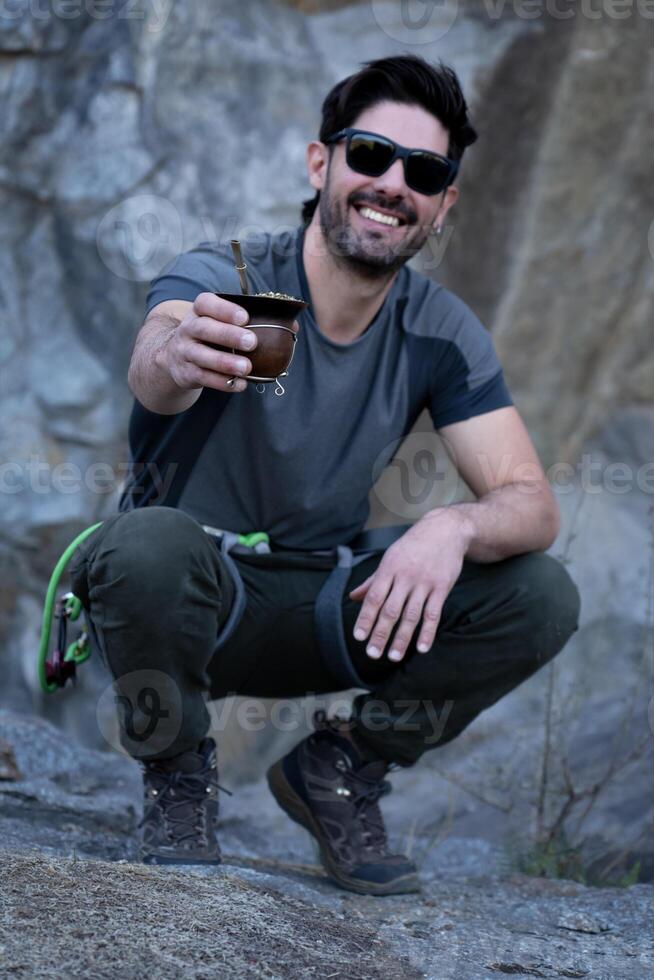 Smiling man enjoying mate tea on a hike in the mountains. photo