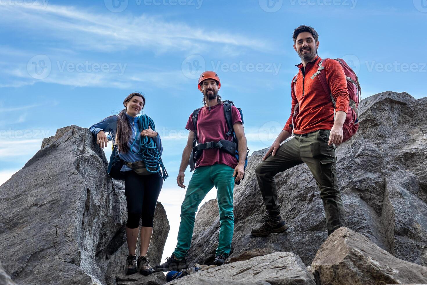 Group of climbers on top of a mountain looking at the camera. photo