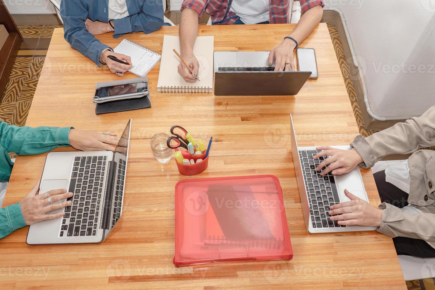 Top view of business people sitting at wooden table and working in office photo