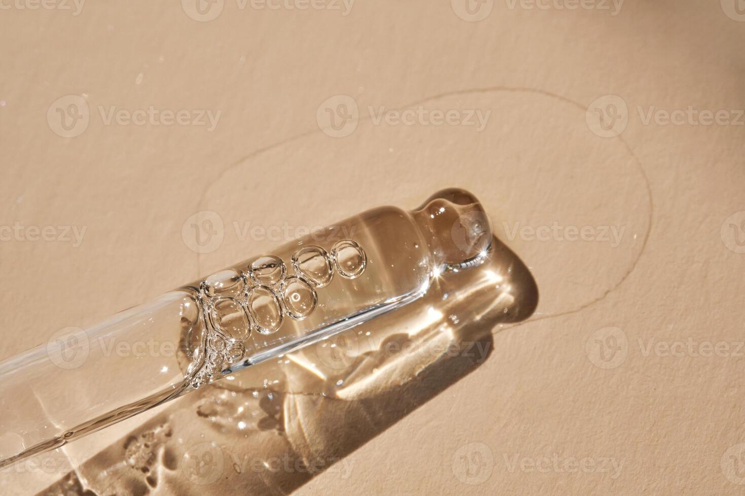Pipette with serum on a beige background. photo