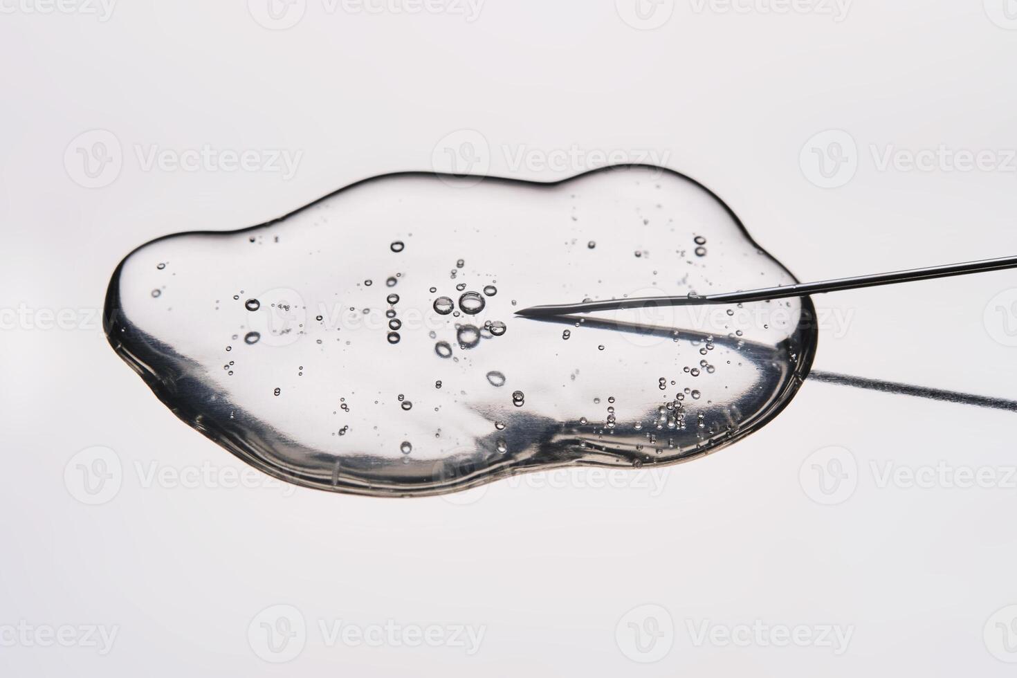 A drop of medicine flowing from a syringe with a needle. photo