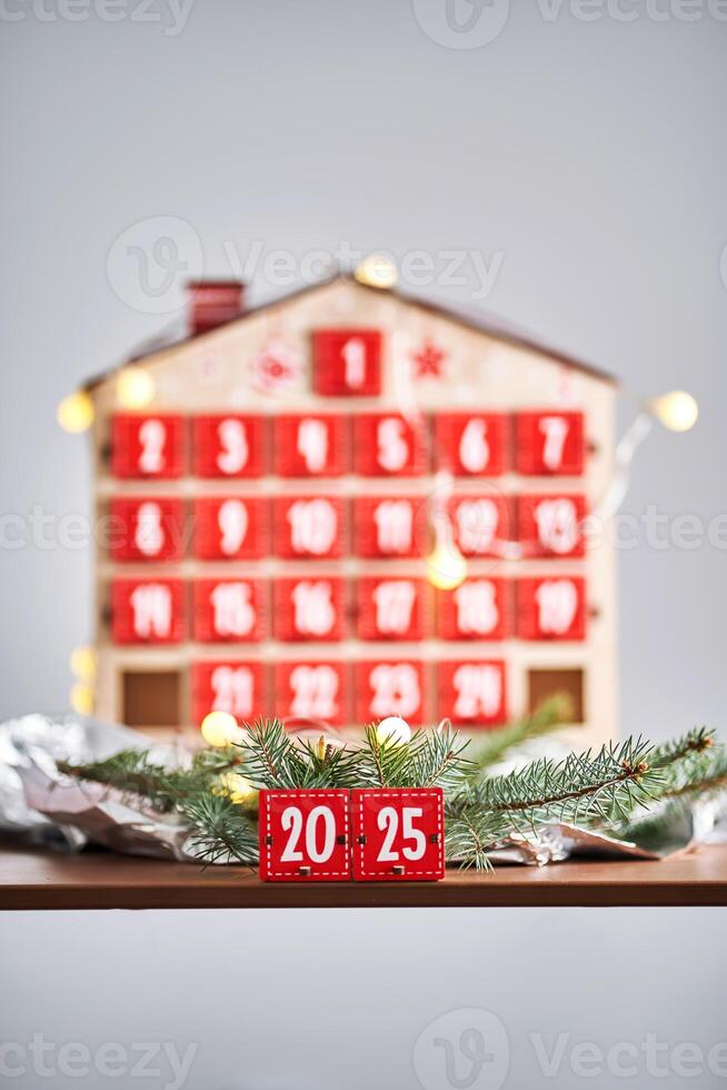 Christmas Advent calendar in the shape of a house with boxes making up the number 2025. photo