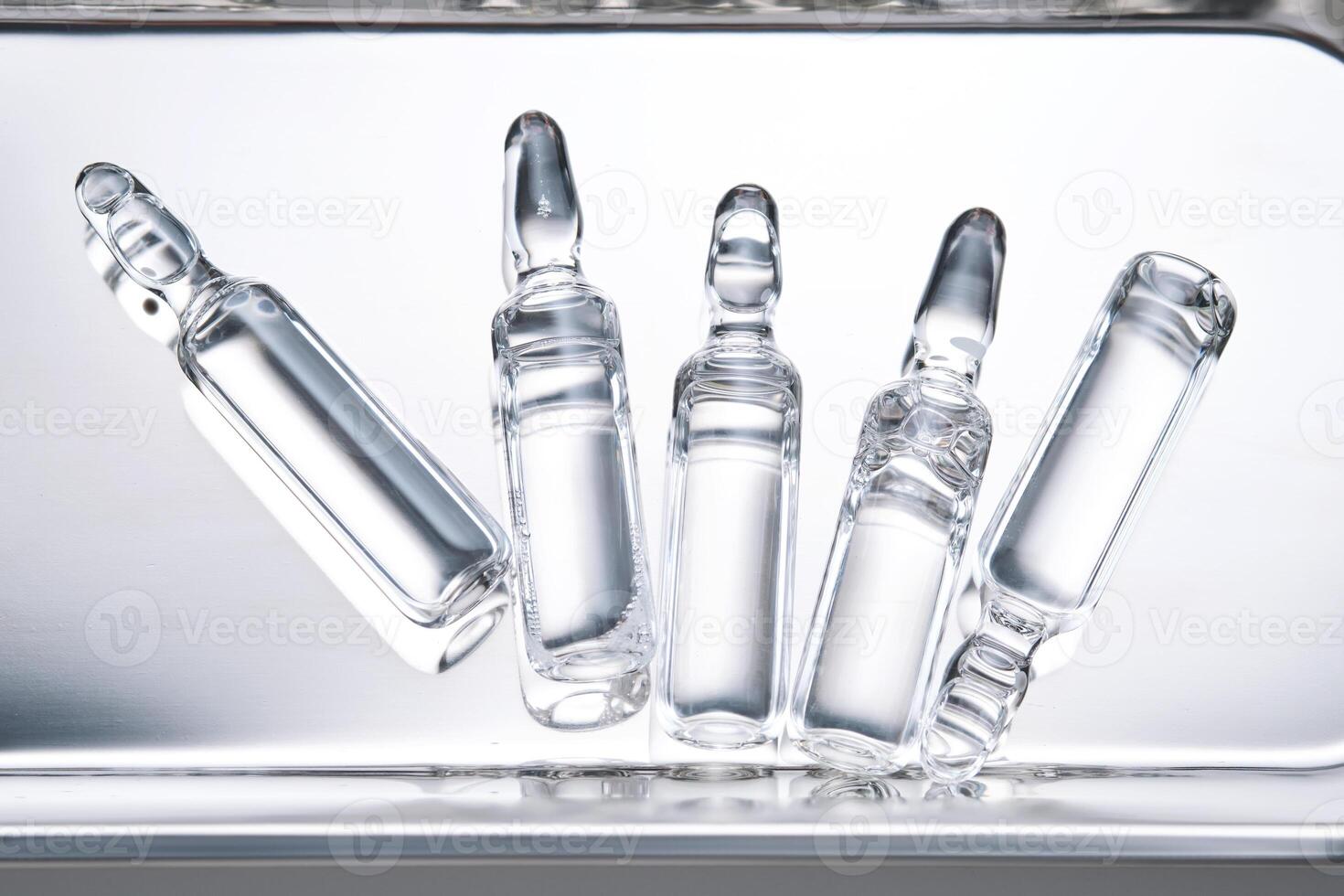 Glass ampoules in a steel medical tray. photo