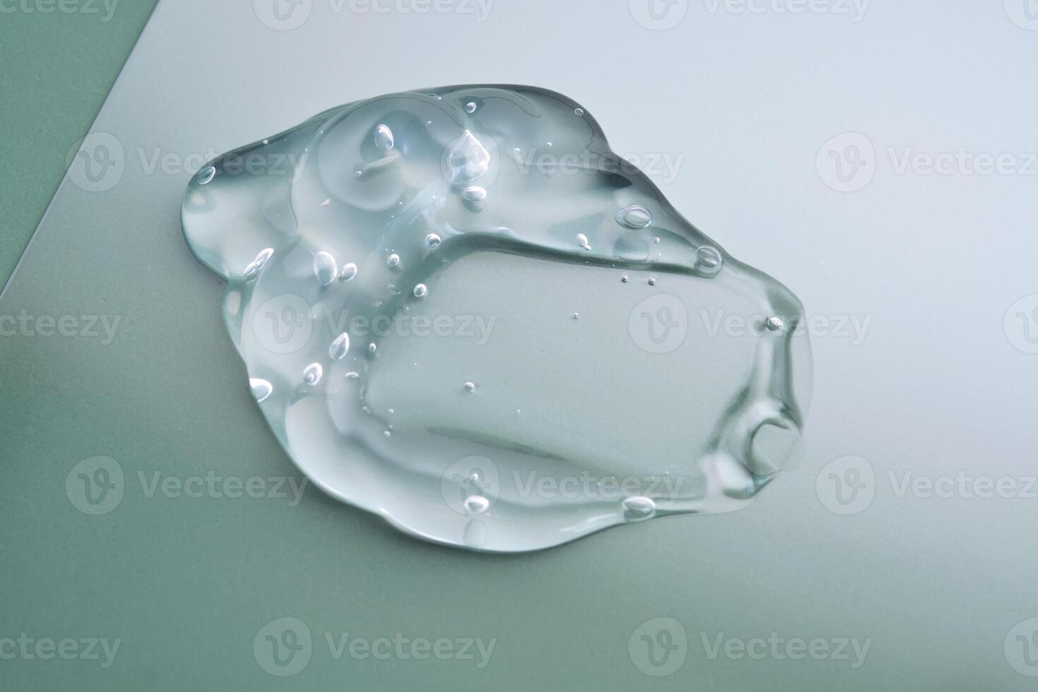 Texture of cosmetic hyaluronic gel or gel lubricant on a green background. photo