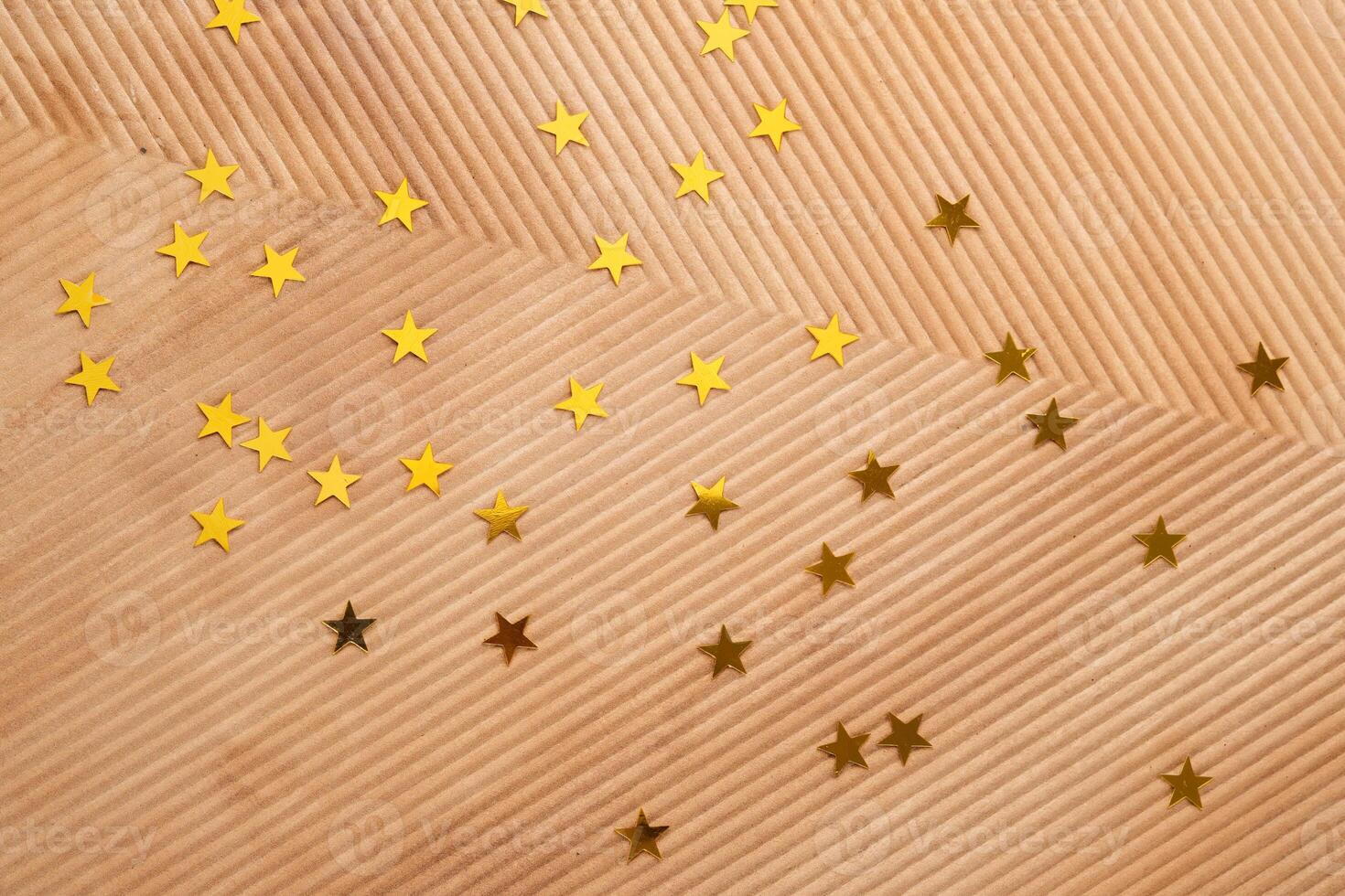 Abstract Christmas corrugated background in beige color with gold stars. photo