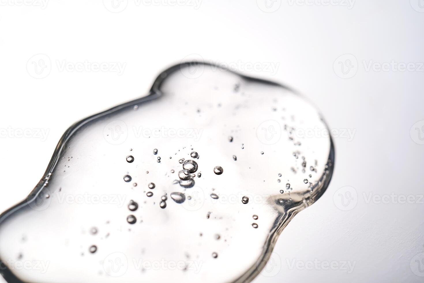 A smear of cosmetic gel close-up on a gray background. Appetizing texture with bubbles. photo