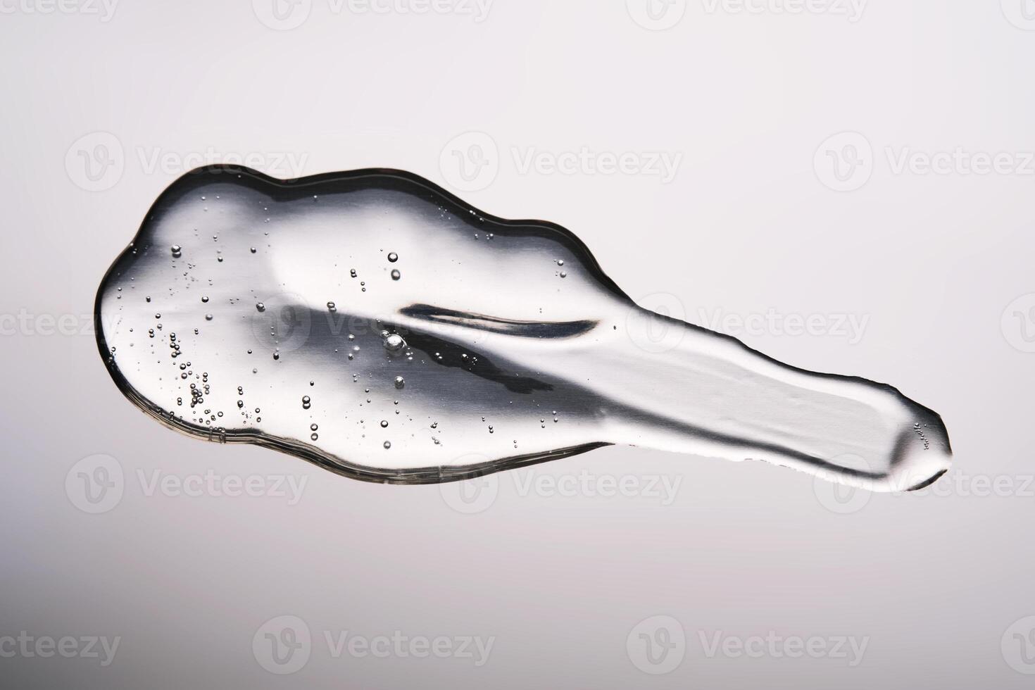 A smear of cosmetic gel close-up on a gray background. Appetizing texture with bubbles. photo
