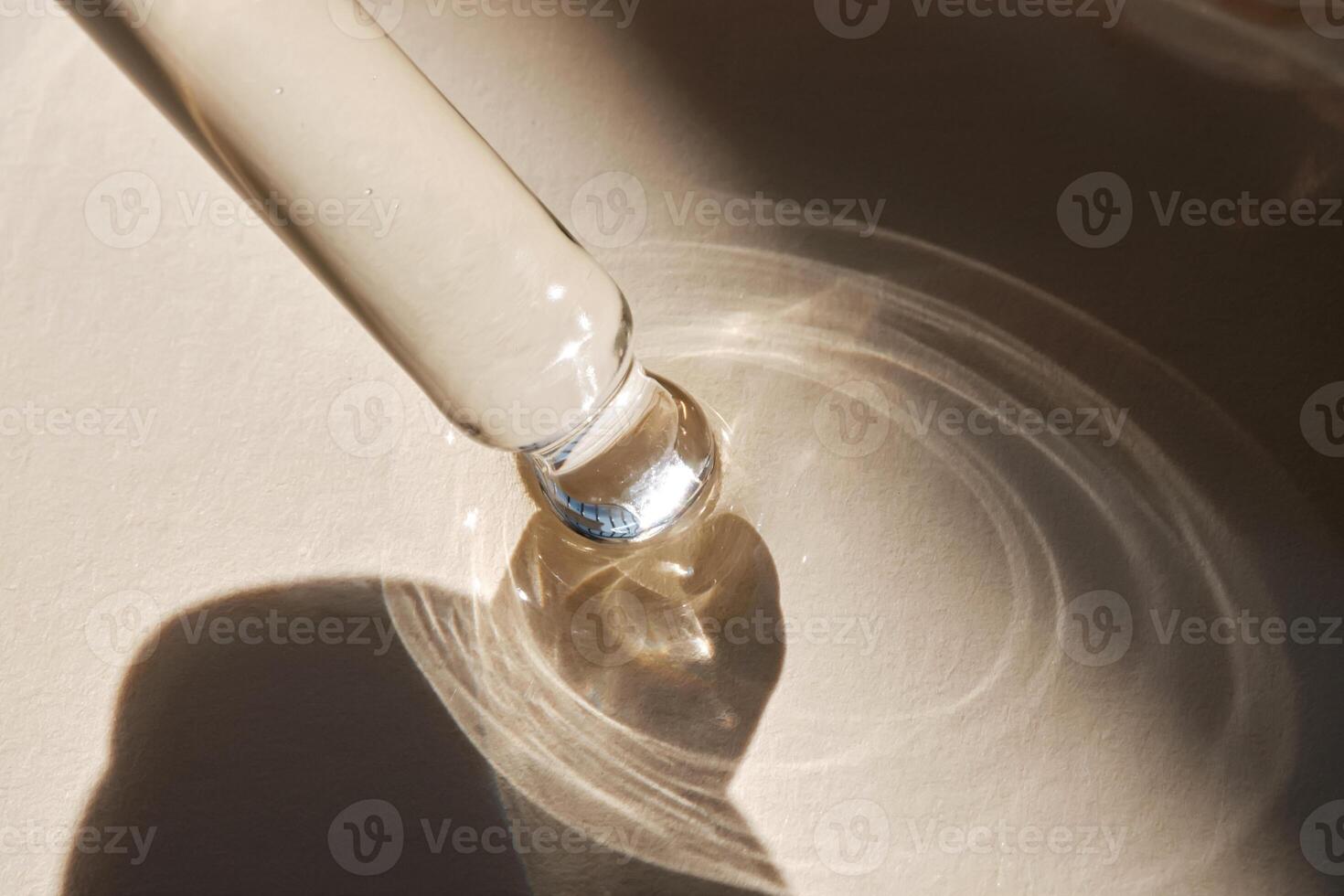 Pipette with serum on a beige background. photo