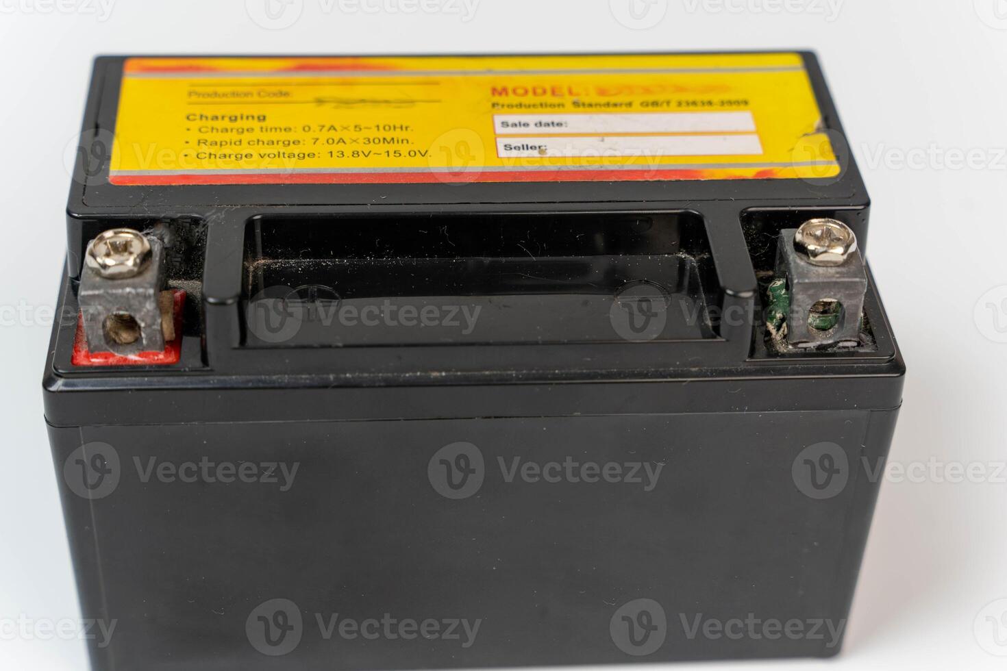 A black motorcycle battery with charging information and terminal posts photo