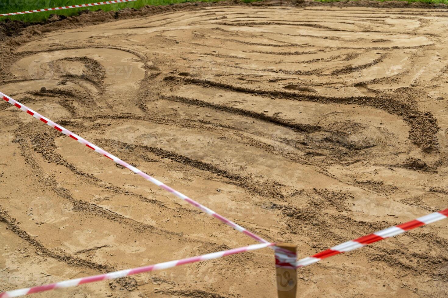 A sandy area marked off by red and white caution tape photo