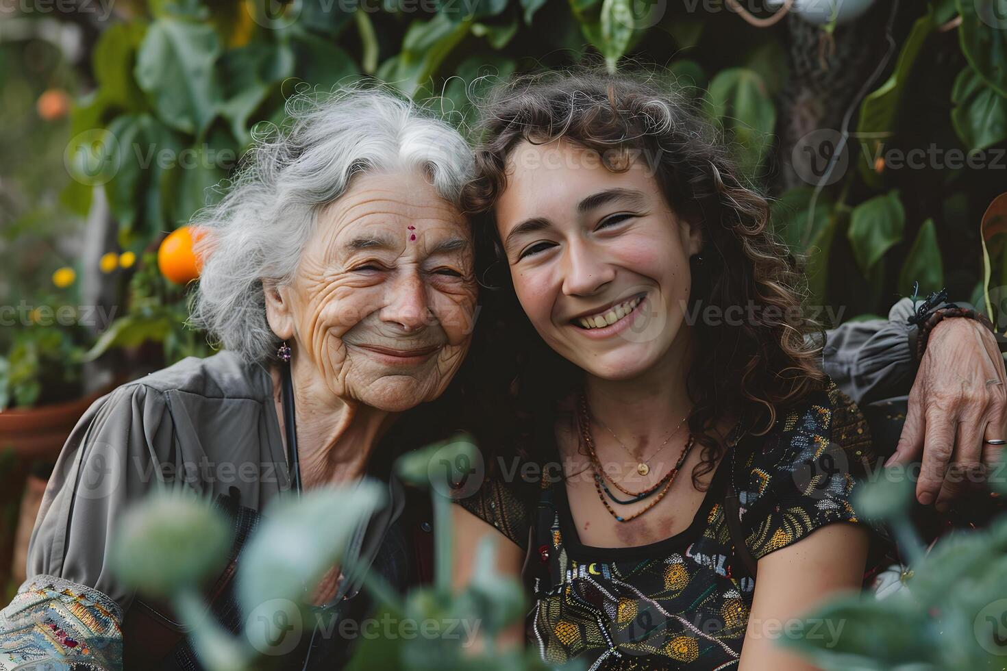 Two women, one older and one younger, smiling together in a garden photo
