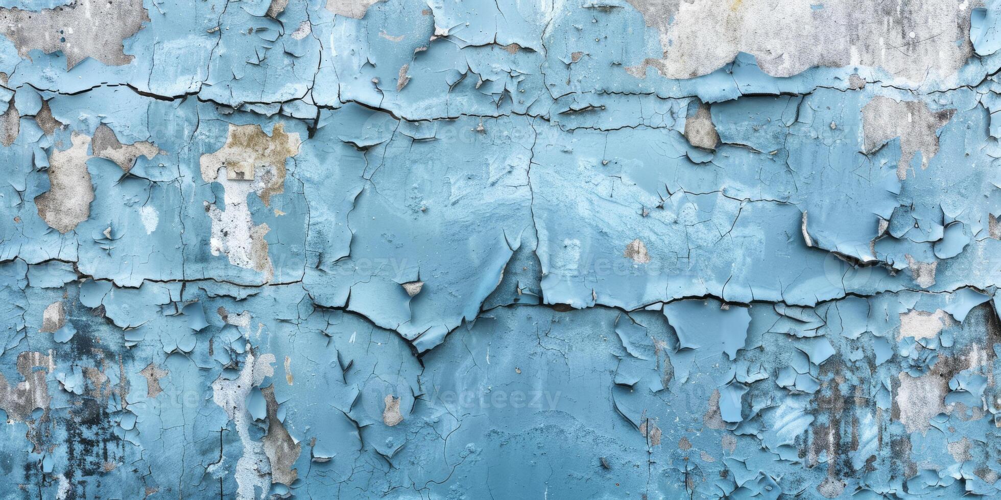 A detailed view of weathered blue paint peeling off an old wall, revealing a textured and worn surface photo