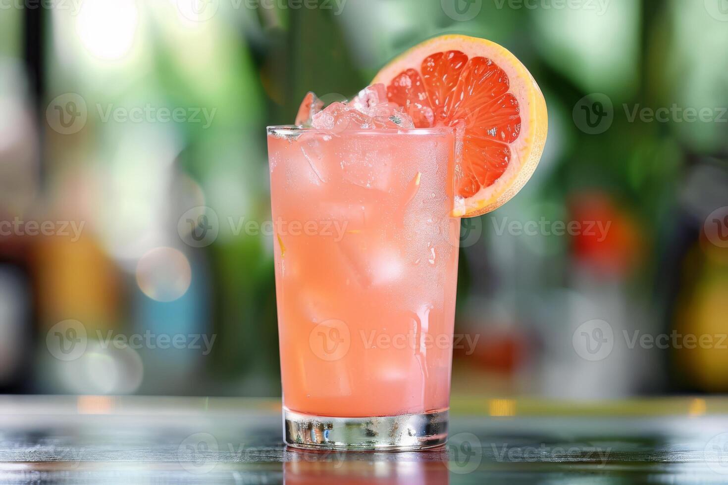 Enjoy the chic ambiance of a retro bar while savoring a pink grapefruit cocktail, a refreshing blend of ice, lime, and tropical flavors. Embrace the elegant setting and celebrate in style photo