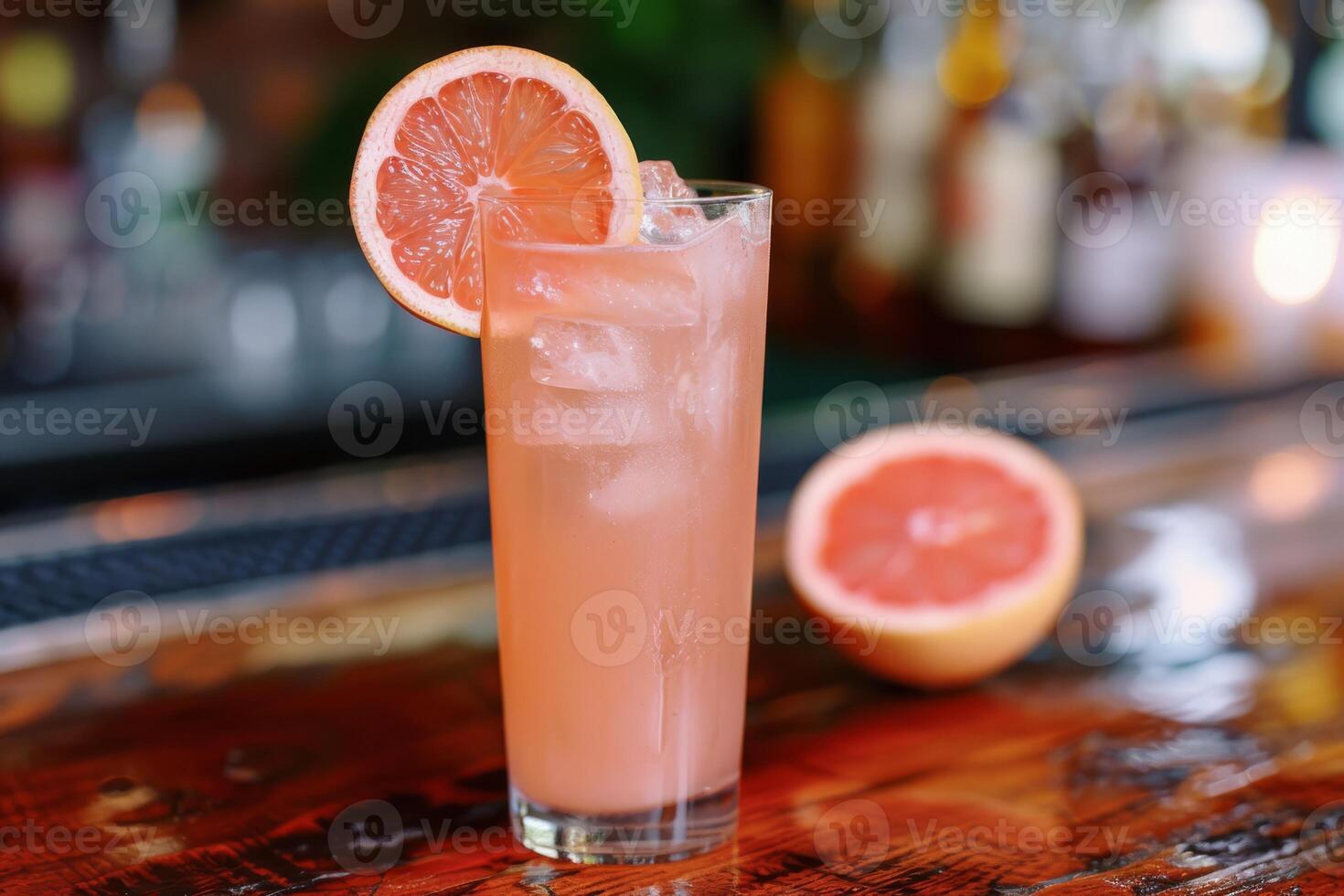 Enjoy the chic ambiance of a retro bar while savoring a pink grapefruit cocktail, a refreshing blend of ice, lime, and tropical flavors. Embrace the elegant setting and celebrate in style photo