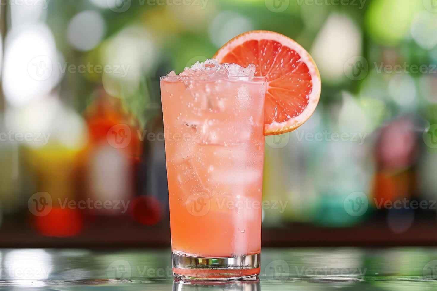 Enjoy the chic ambiance of a retro bar while savoring a pink grapefruit cocktail, a refreshing blend of ice, lime, and tropical flavors. Embrace the elegant setting and celebrate in style photo