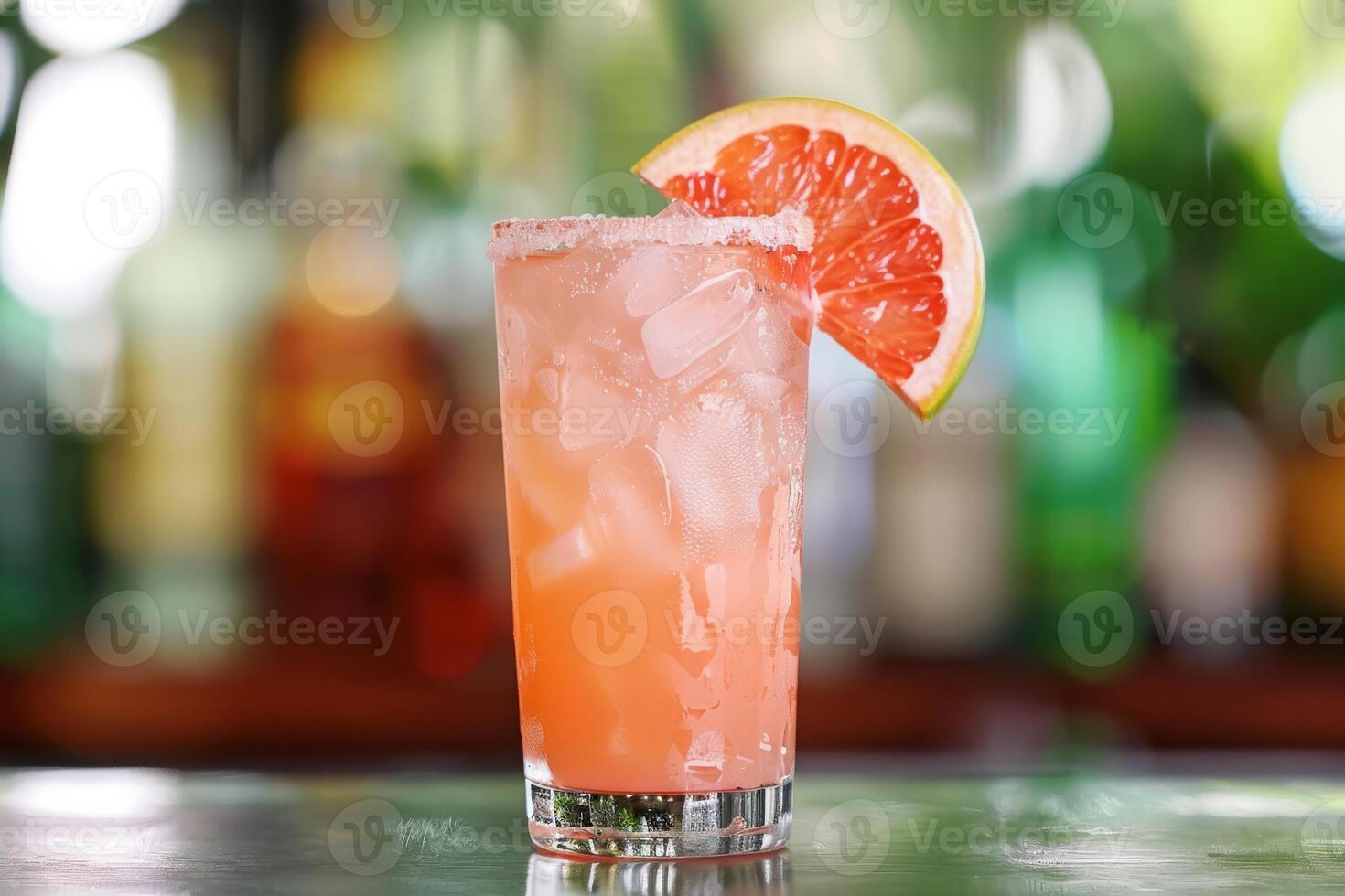 Enjoy the chic ambiance of a retro bar while savoring a pink grapefruit cocktail, a refreshing blend of ice, lime, and tropical flavors. Embrace the elegant setting and celebrate in style photo