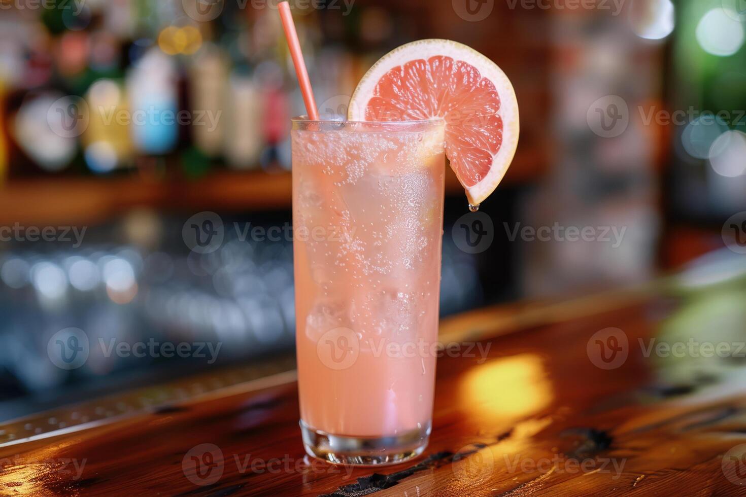 Enjoy the chic ambiance of a retro bar while savoring a pink grapefruit cocktail, a refreshing blend of ice, lime, and tropical flavors. Embrace the elegant setting and celebrate in style photo