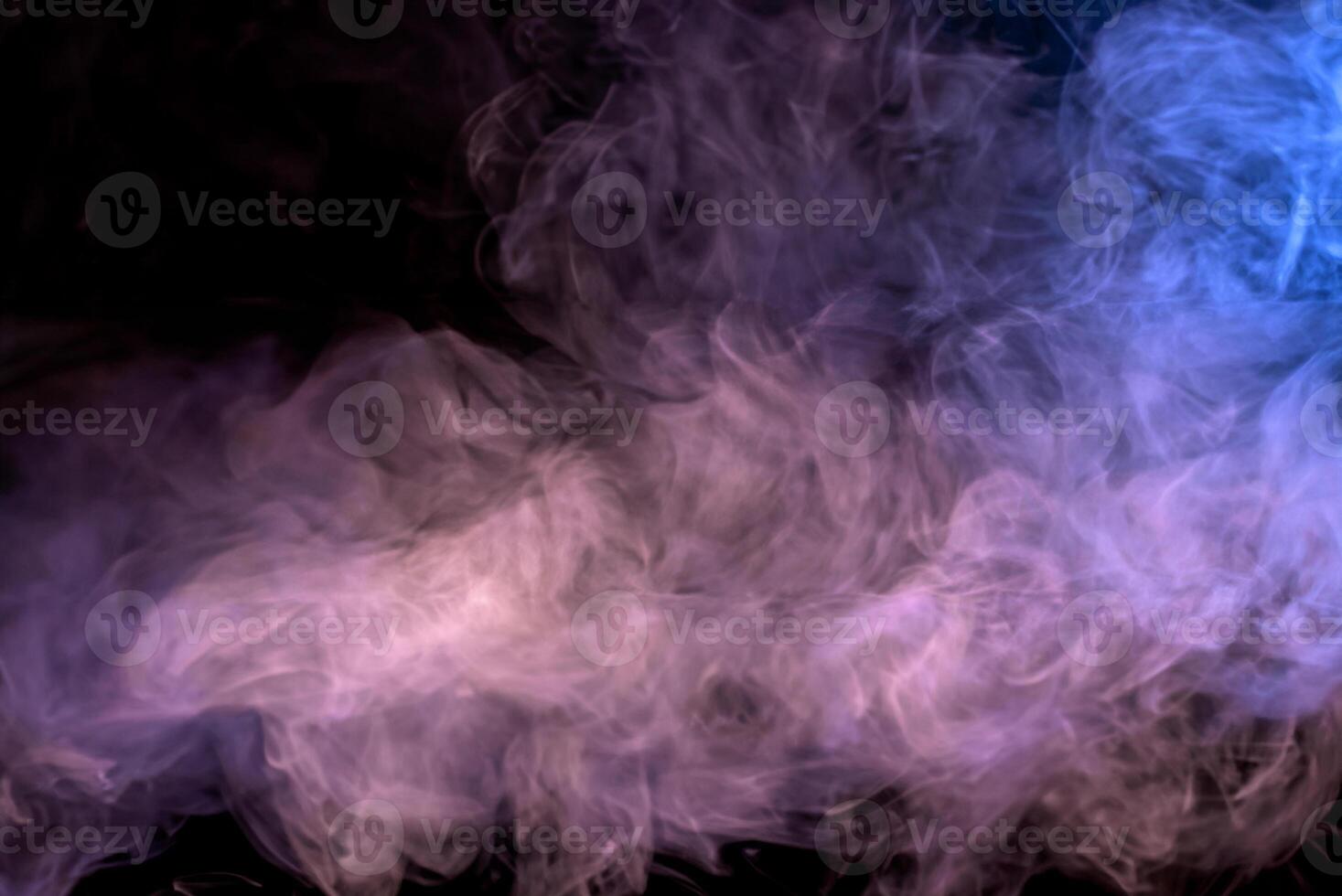 Abstract Multicolored Smoke on Black Background and Wooden Table photo