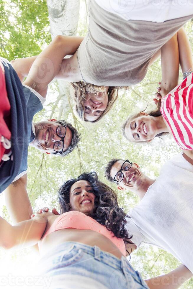 group of smiling friends in circle - bottom view photo