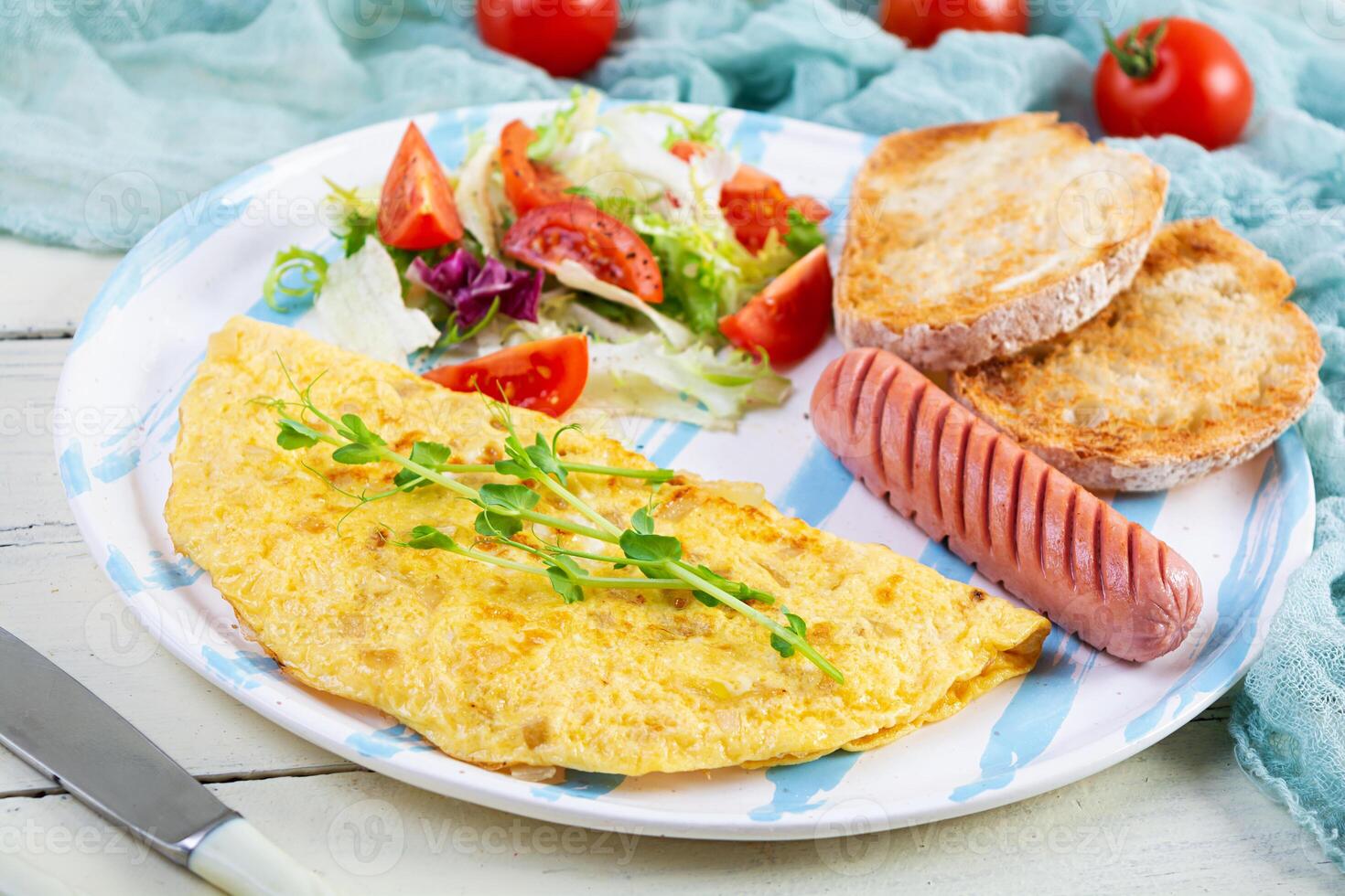 Fried omelette with sausage and salad. Delicious breakfast with eggs and toast photo