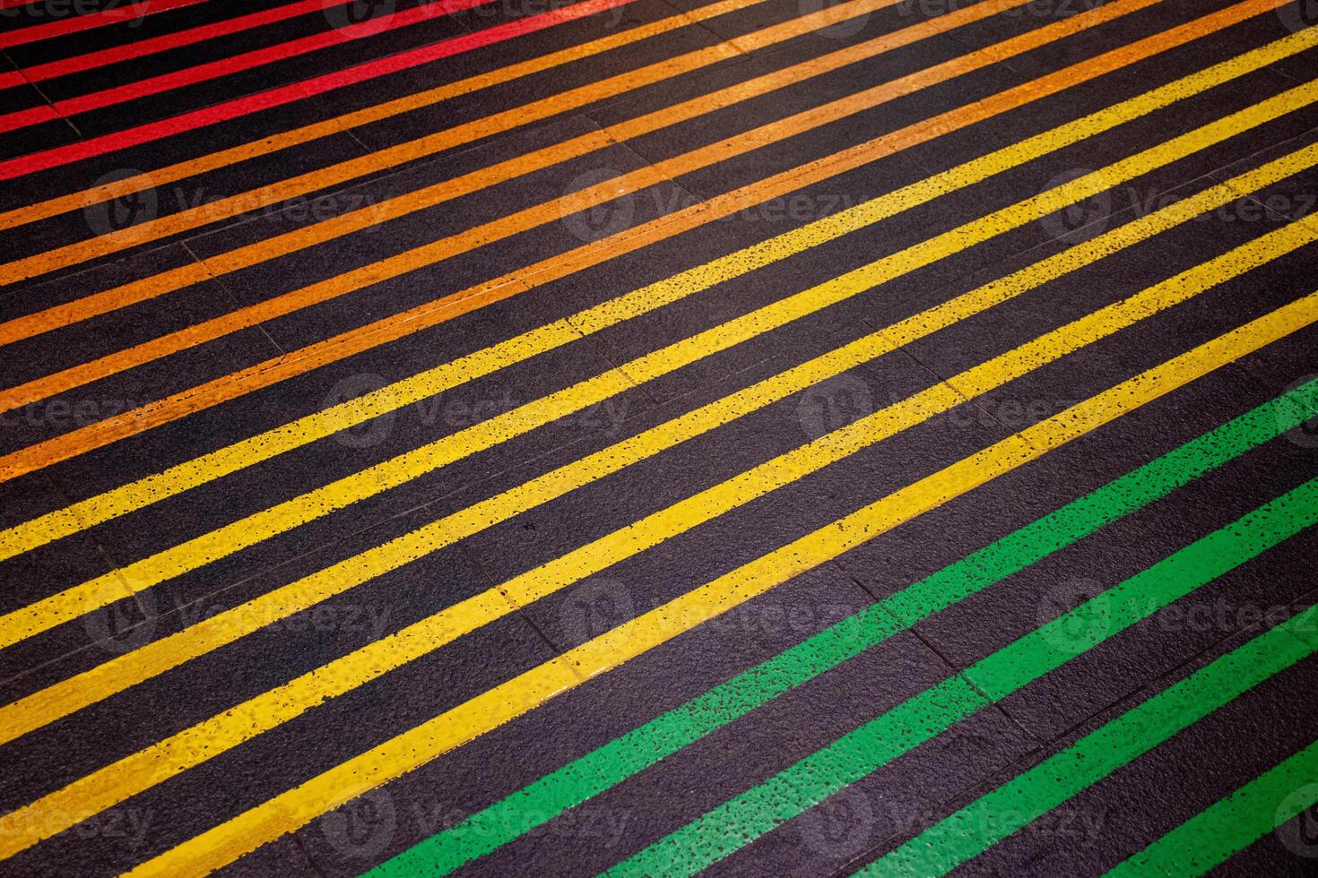 Colorful lines on the black floor and walkway. Crossing the street on a multi colored crosswalk painted with the colors of the pride flag. Rainbow color. photo