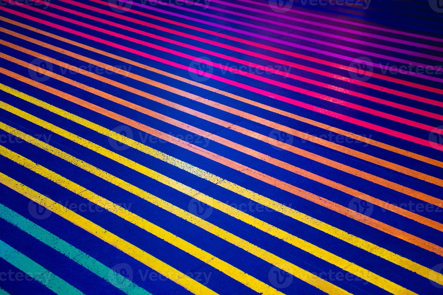 Colorful lines on the blue floor and walkway. Crossing the street on a multi colored crosswalk painted with the colors of the pride flag. Rainbow color. photo