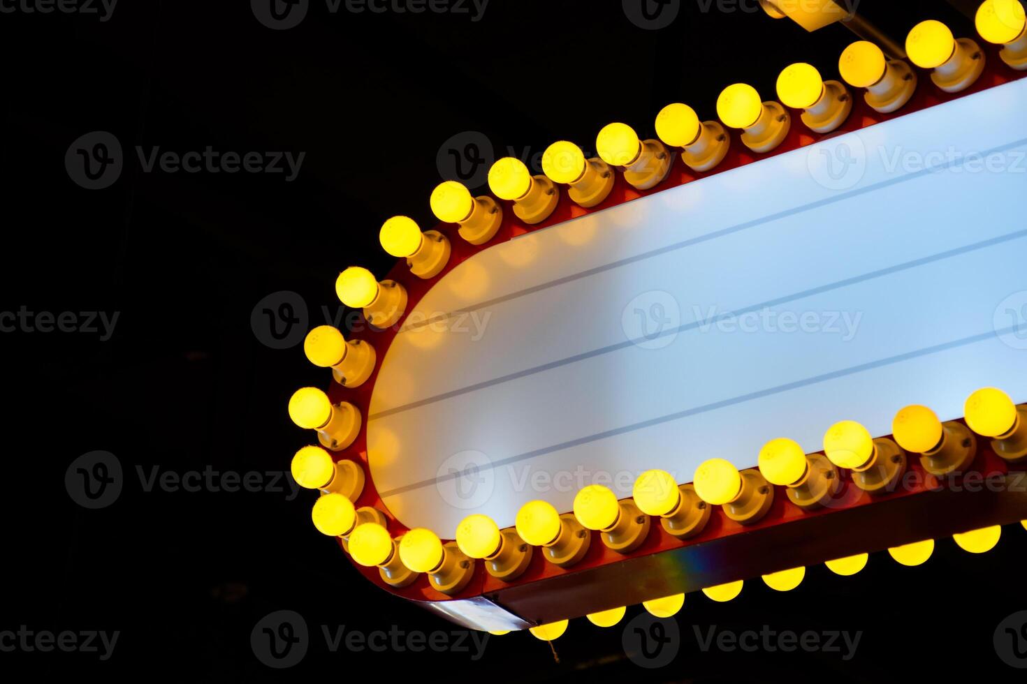 Close up yellow neon light sign red frame and white copy space for add text against black background. Modern lighted signs for decorating buildings or place. photo