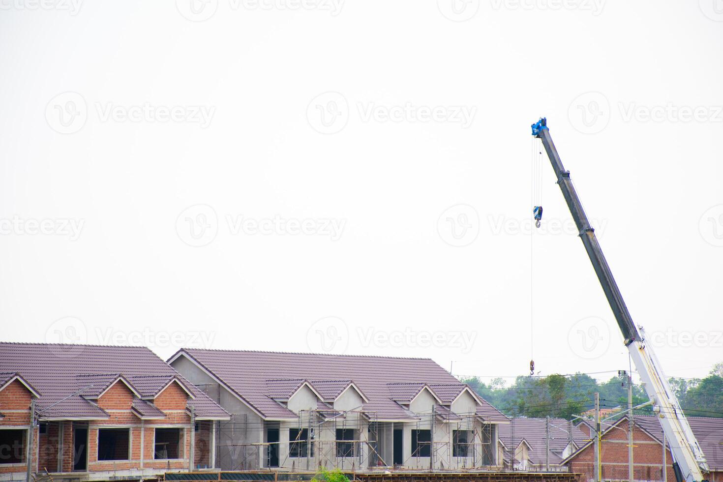 Building and onstruction site with construction crane of new home for housing against clear sky background. Modern house under construction and crane 2025. photo