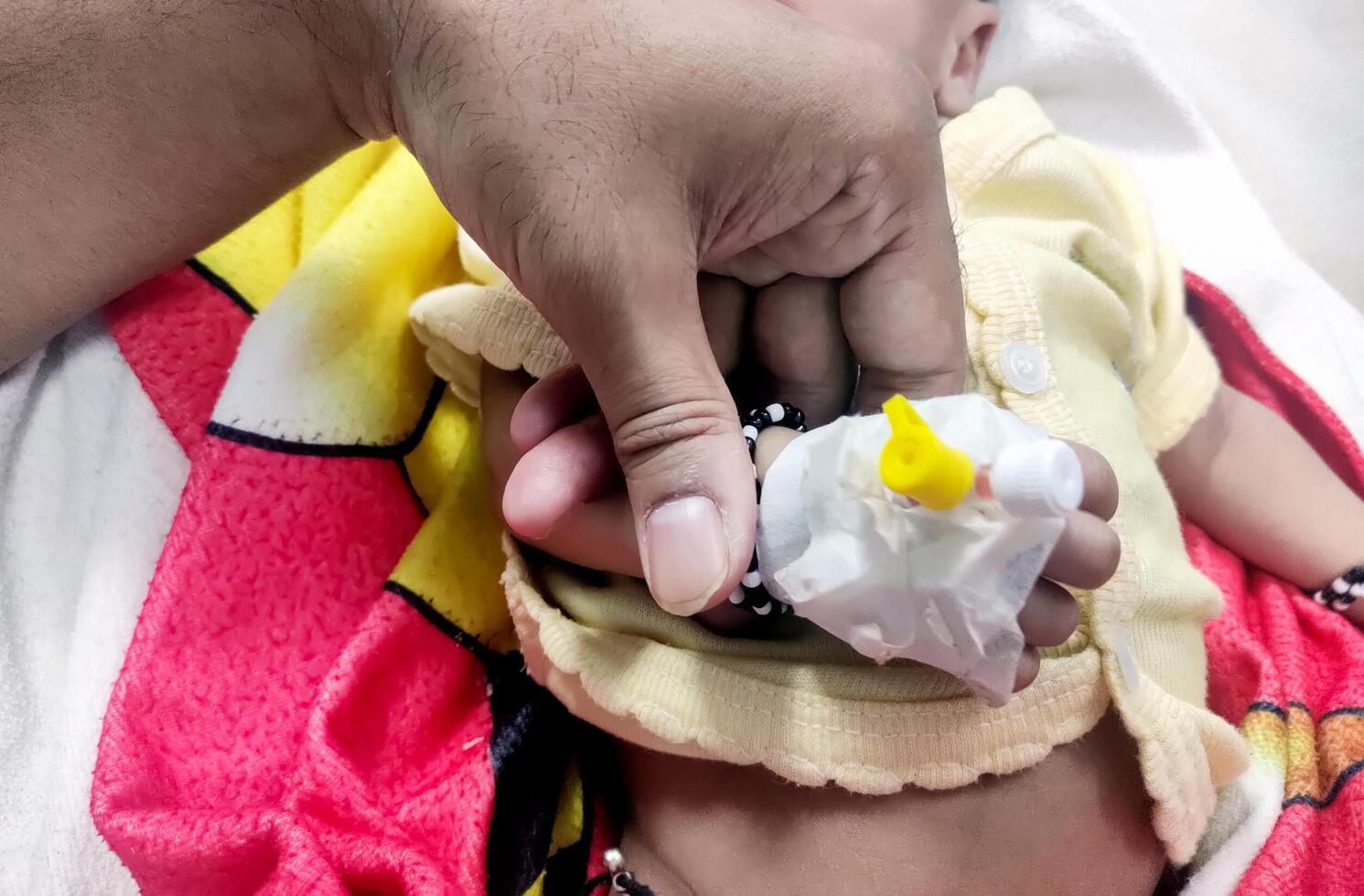 Children patient's hand recieving iv saline solution in hostpital photo