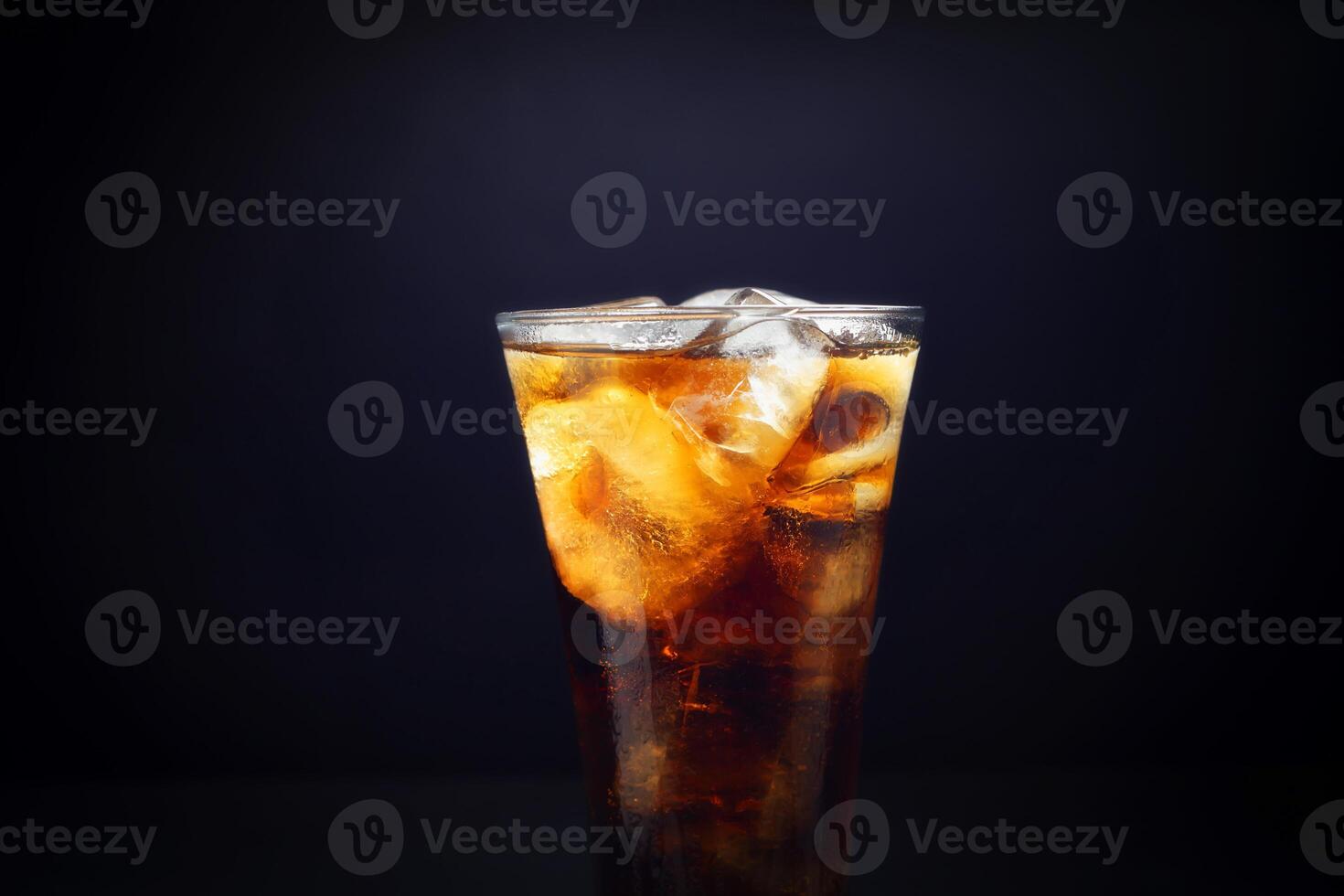 Close-up of soft drinks A glass of delicious refreshing summer water with ice cubes, isolated on black background. Closeup photo
