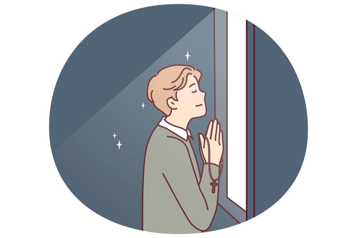 Religious man prays standing at window and holds chain with catholic christian crucifix in hands vector
