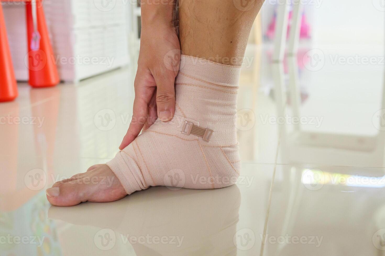 Man with ankle sprain elastic bandage for ankle injury and feeling pain photo