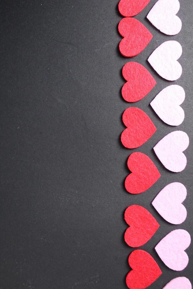 Red and pink hearts on a black dark background with space for text. Copy Space Valentine's Day. Festive background photo