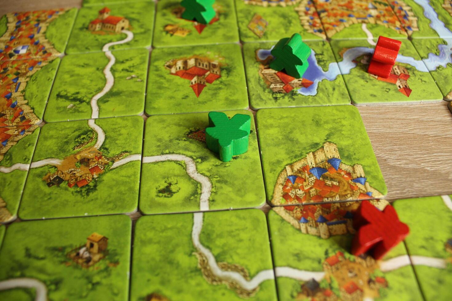 board game carcassonne red green meeple lie on the field map game rules for occupying the field photo