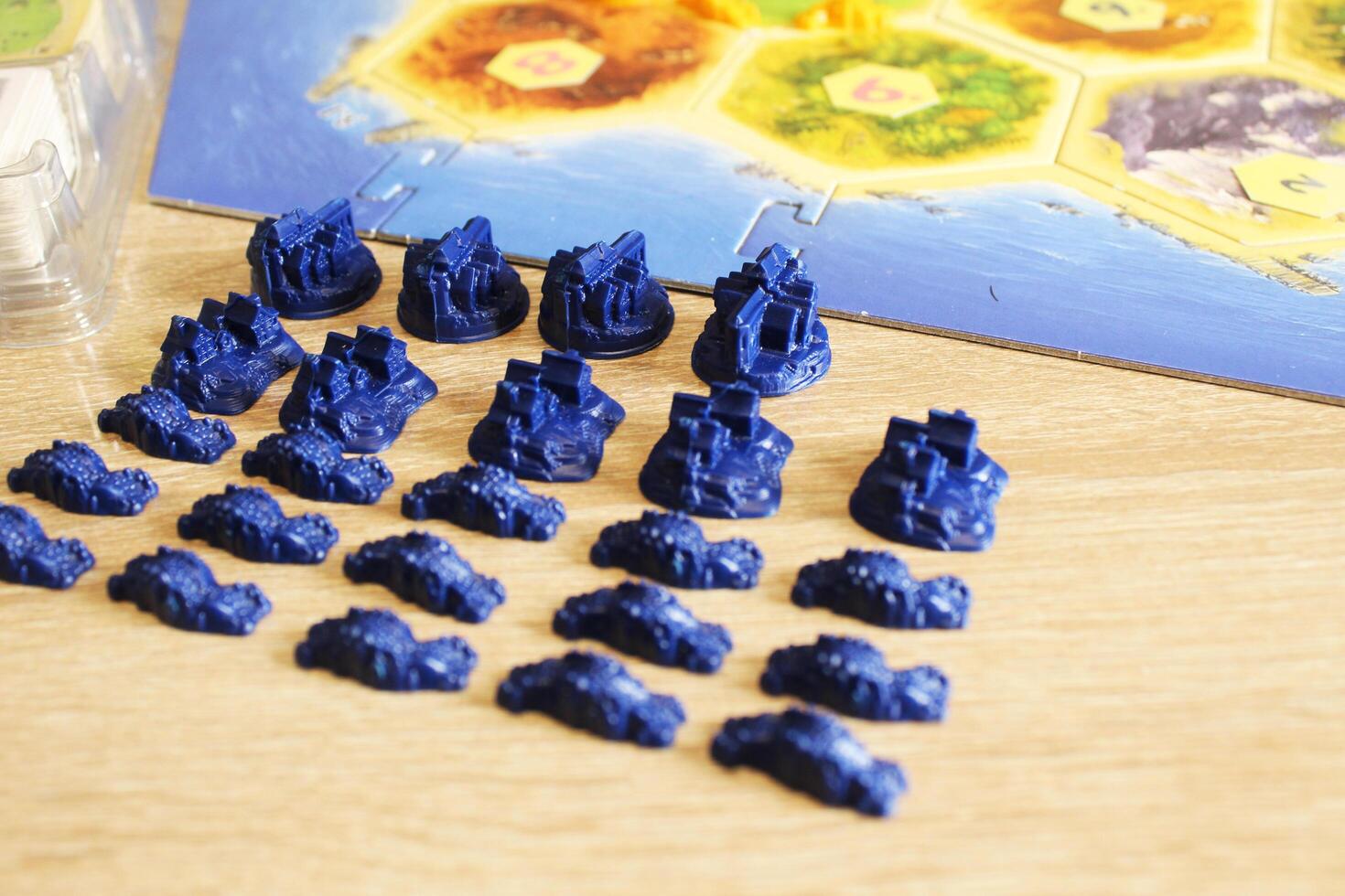 A catan board game neatly arranged blue player figure chips. Preparing for the game photo
