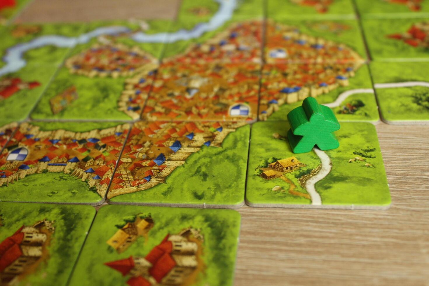 Carcassonne green meeple family board game took the road on a tile with a road. Rules for connecting hoists to the road photo