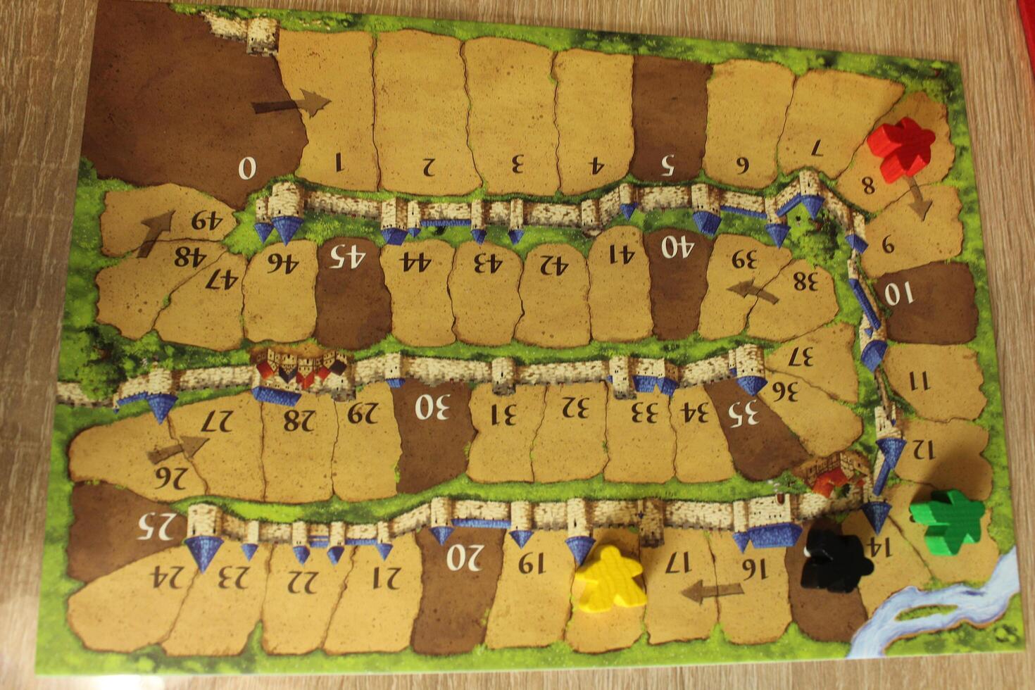 Tablet for calculating the progress of players in the board family game Carcassonne. Red Yellow Melinated Black Meeple on Tablet. Gameplay photo