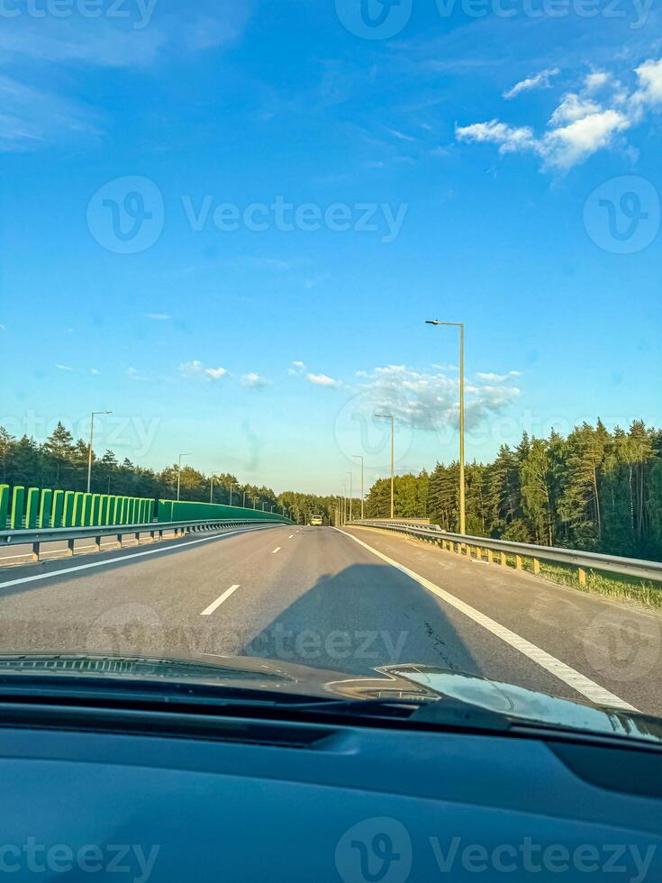 summer road view from the front seat of the car . High quality photo