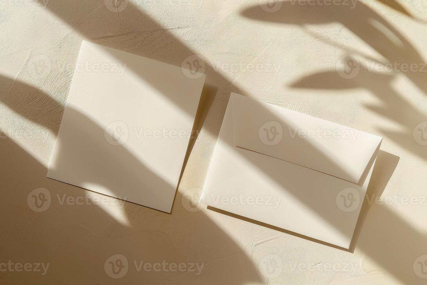 Flat lay of two rectangular blank cards and white envelope on ivory background with shadows. Top view photo