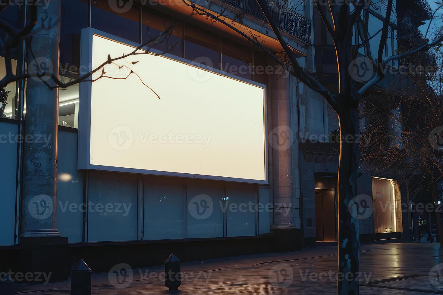 An empty billboard on a building exterior for mockup advertisement, at dusk with a lit interior backdrop photo