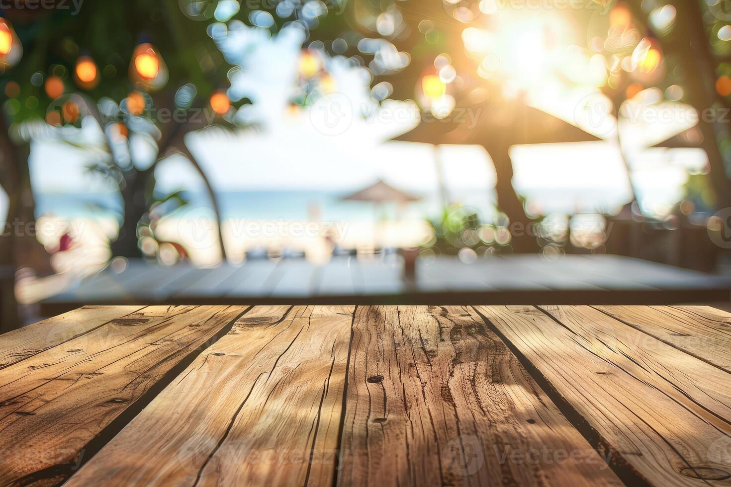 Empty wooden table top with copy space for food drink product advertising with blurred summer resort beach bar restaurant background photo