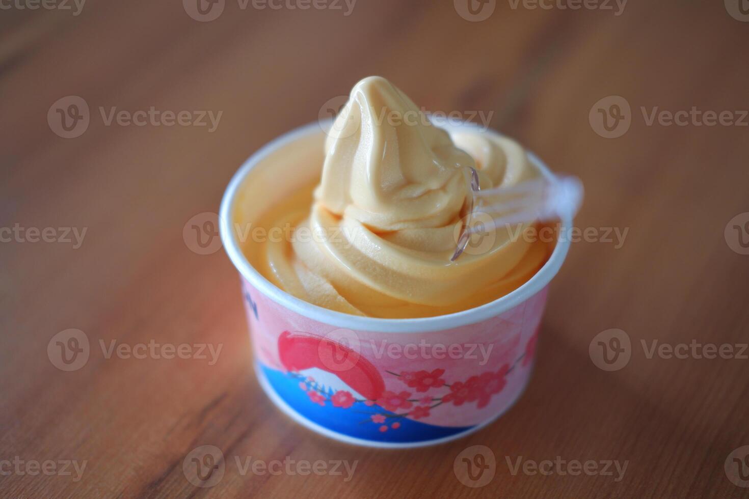 ice cream in paper cup on wood table background. soft focus. photo
