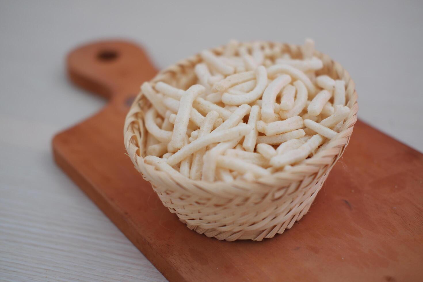 delicious onion flavored snack in wicker basket photo
